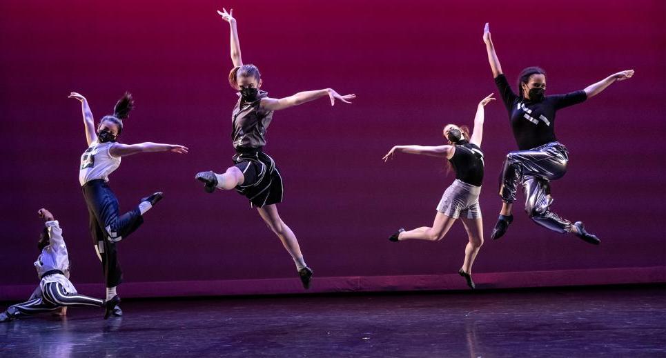 Image of dancers jumping on stage
