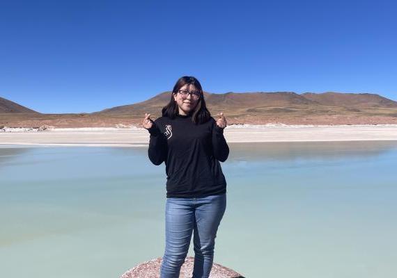 Michelle Lamadrid Benavides站在湖边做手指心形. 