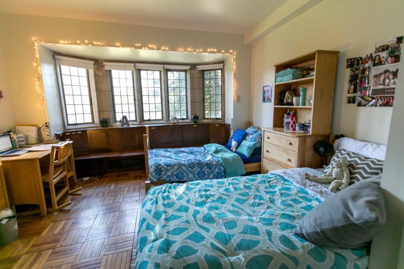 Dorm room with two beds and a window seat