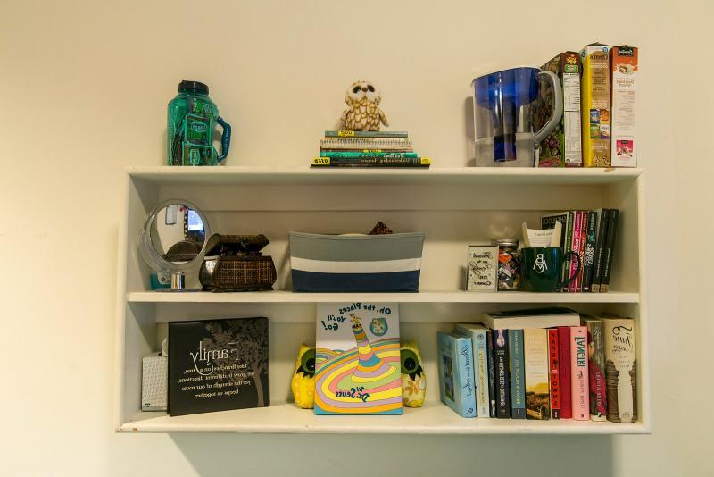 A dorm room shelf with books and other objects